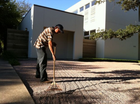 Man raking front yard gravel